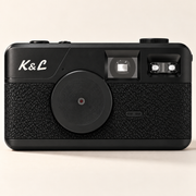 Zwarte K&L Retro Camera in een lichte studio-opstelling.